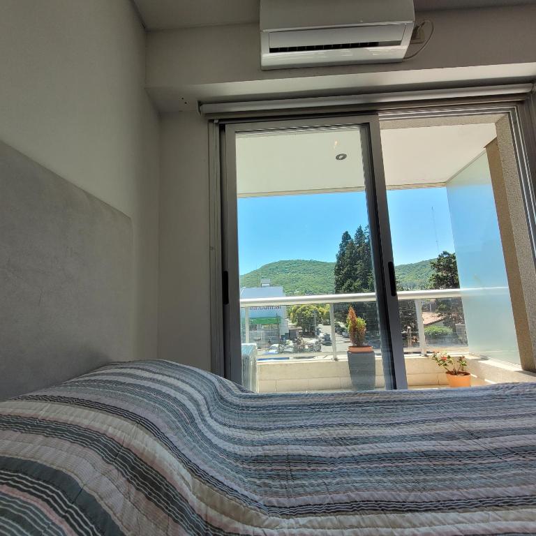 ein Schlafzimmer mit einem Bett und einem großen Fenster in der Unterkunft Salta Hills in Salta