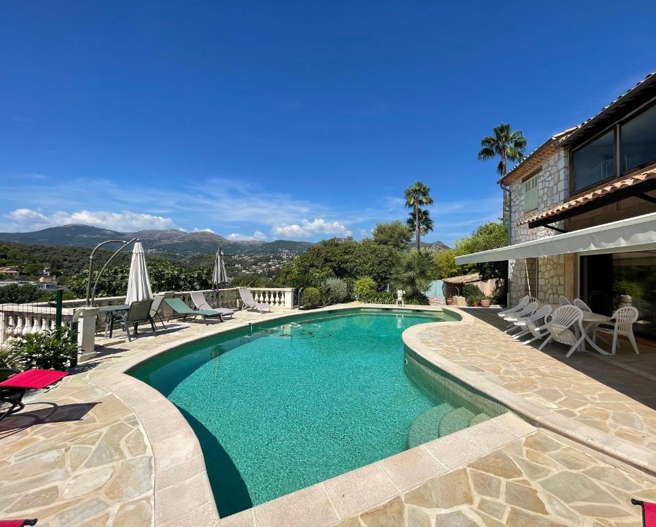 une piscine avec une terrasse et un bâtiment dans l'établissement LA BASTIDE DE CHARME, à Vence