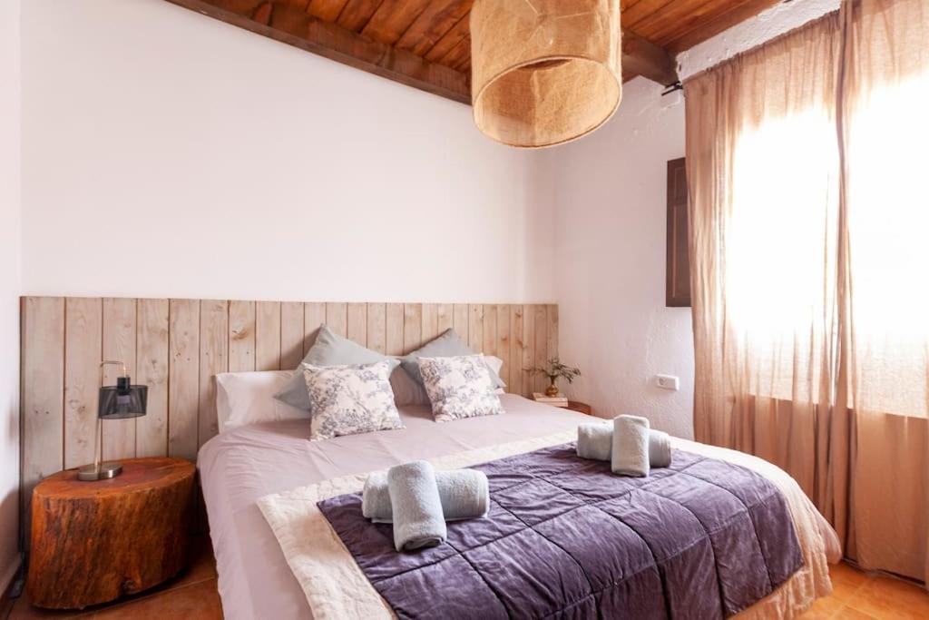ein Schlafzimmer mit einem großen Bett mit Handtüchern darauf in der Unterkunft LOS TILOS Casa rural en el campo. in Tordera