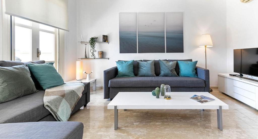 una sala de estar con un sofá y una mesa en Modern Apartment U2 - Zias with lovely views in heart of Aphrodite Hills, en Kouklia