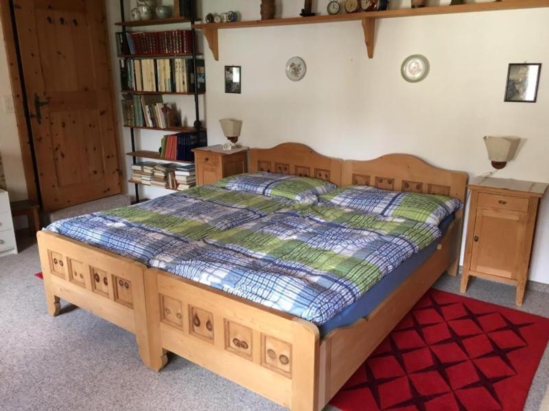 ein Schlafzimmer mit einem Holzbett in einem Zimmer in der Unterkunft Scuol in schönem Engadinerhaus in Scuol