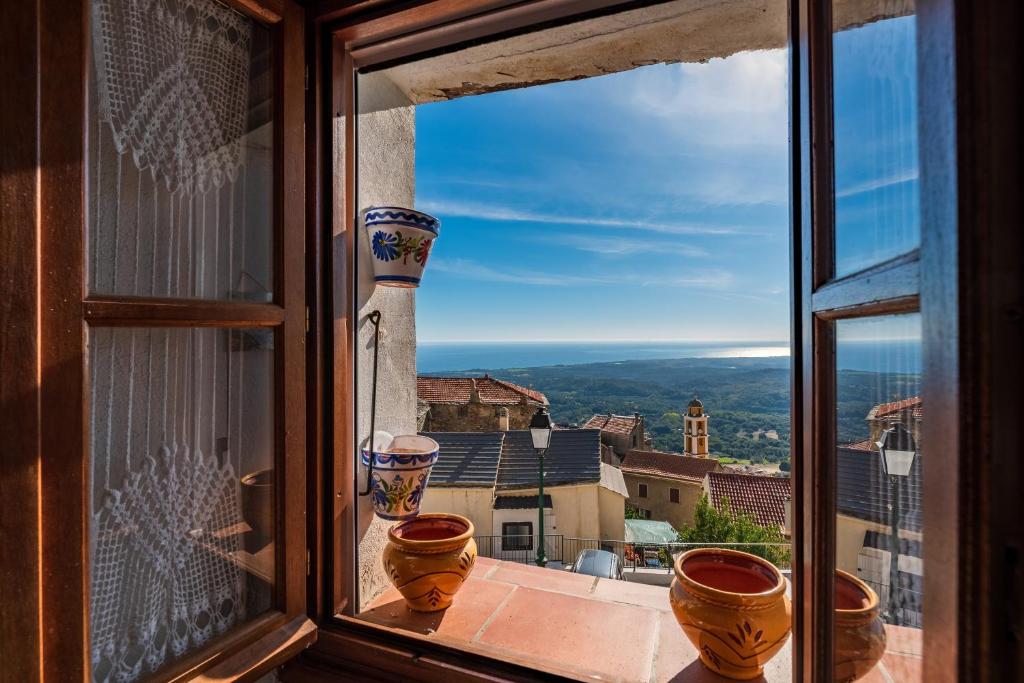 a view from a window with pots on a balcony at Pentone in Cervione
