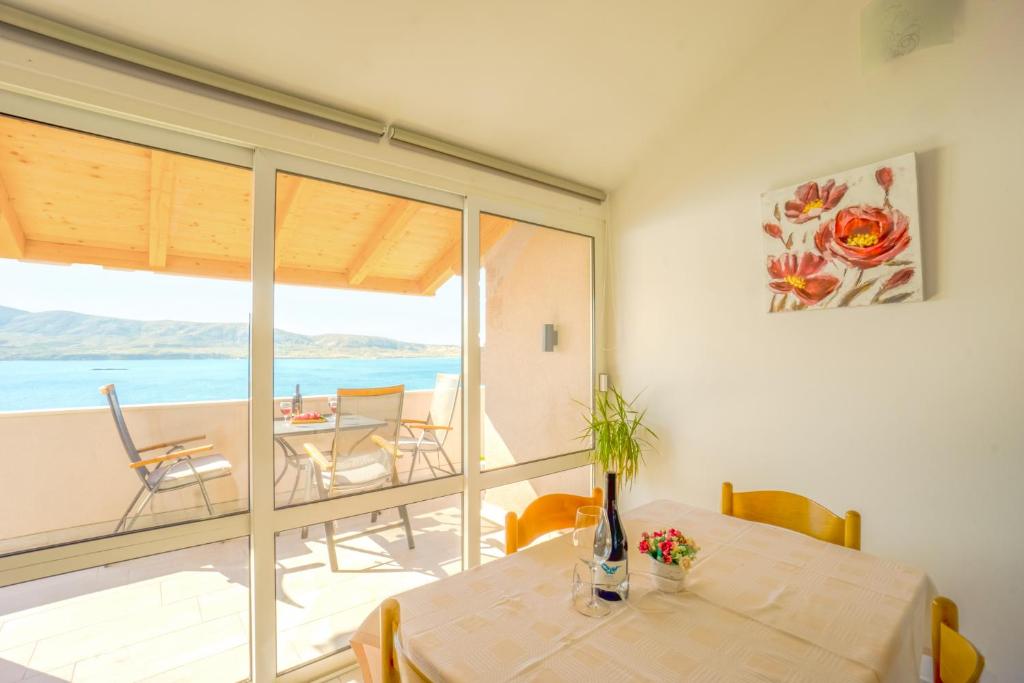 een eetkamer met een tafel en uitzicht op de oceaan bij Marva stylish Mediterranean accomodation with beautiful view in Zubovići