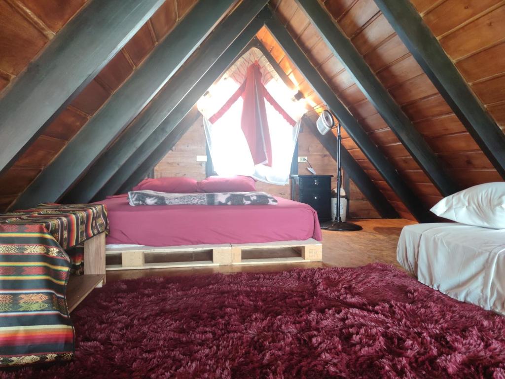 1 dormitorio con 2 camas y ventana en el ático en Alpina Glamping en Latacunga, en Saquisilí