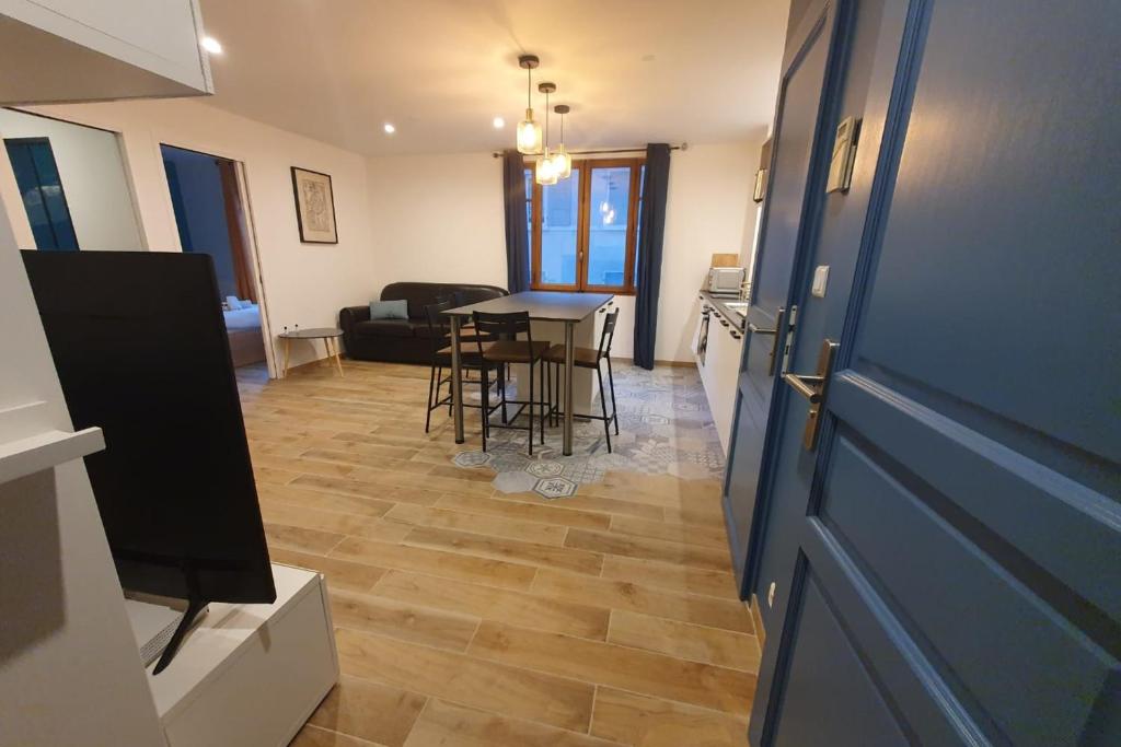 salon ze stołem i niebieskimi drzwiami w obiekcie Le Thiou - Apartment for 4 people 5 minutes from the center w Annecy