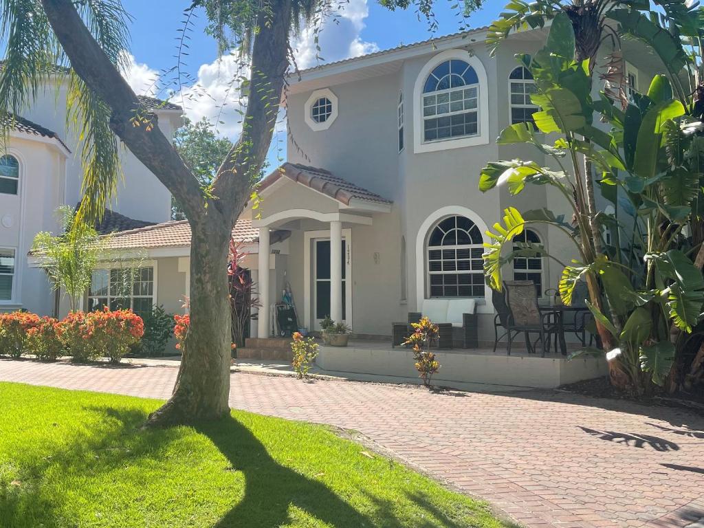 a white house with a tree in the yard at Siesta Key Bay View in Siesta Key