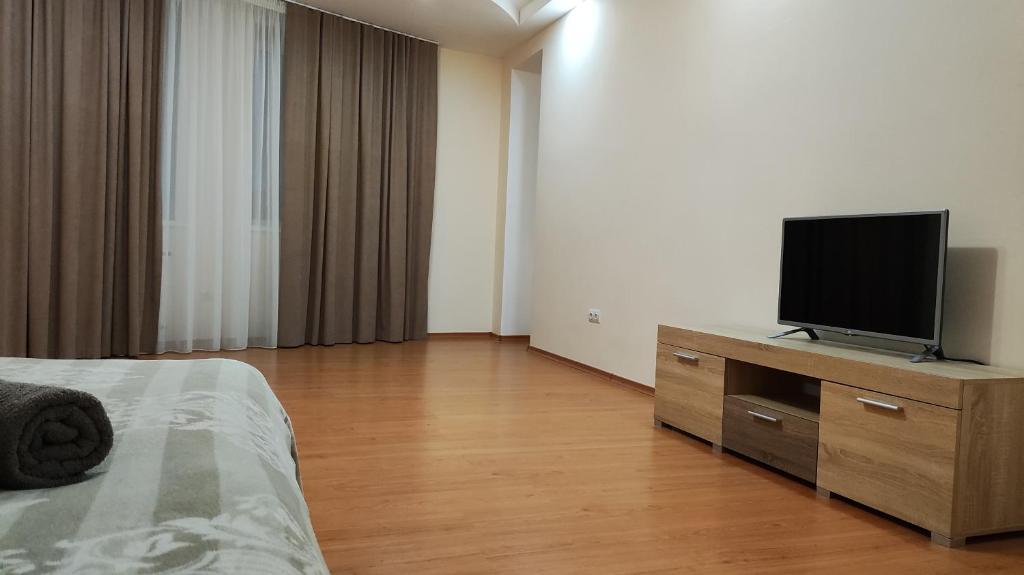 a bedroom with a bed and a television on a dresser at Запорізька 19 City Rooms in Bila Tserkva