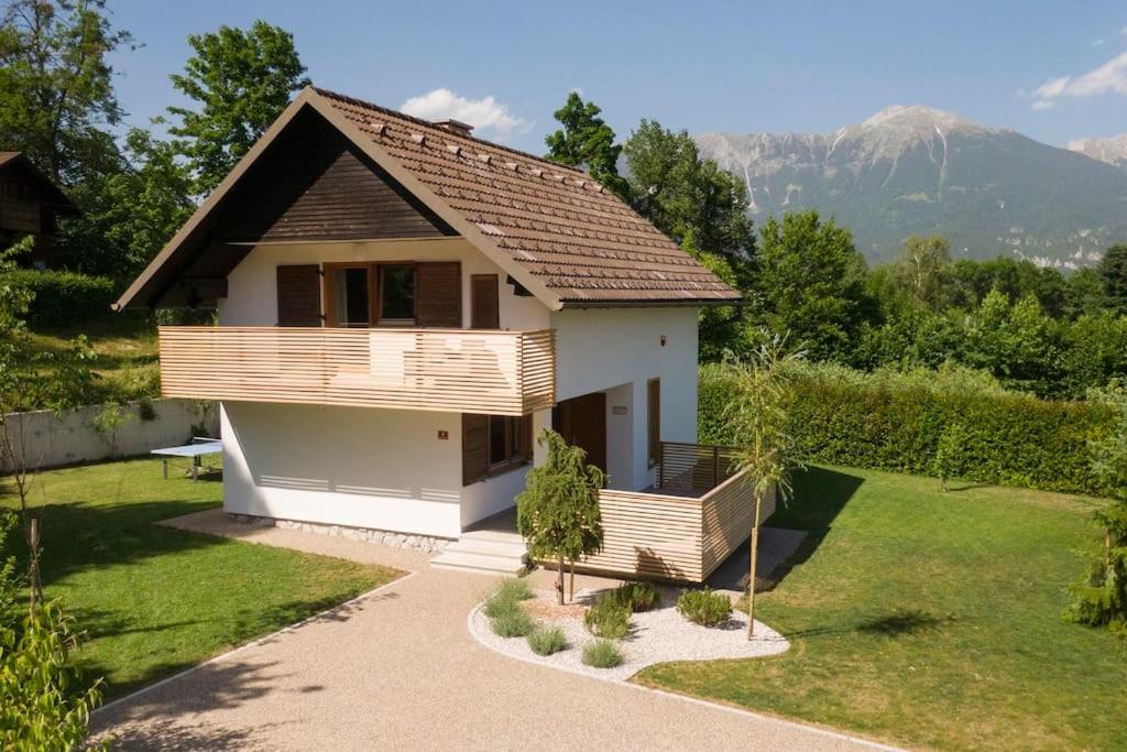 a small house with a balcony and a yard at Private green getaway in Bled