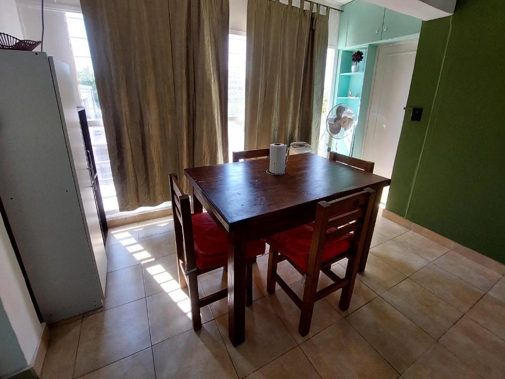 una mesa de madera y sillas en una habitación con ventana en Departamento en ciudad de.Mendoza en Mendoza