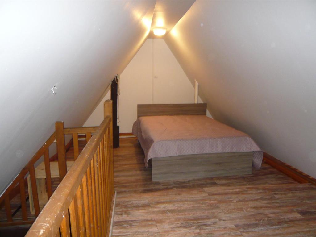 a attic room with a bed and a staircase at La cour des meuniers - le Froment et l&#39;Epeautre in Kaysersberg