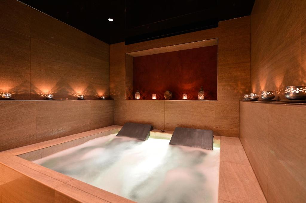 a bath tub with two chairs in a room at Matterhorn Lodge Boutique Hotel & Apartments in Zermatt
