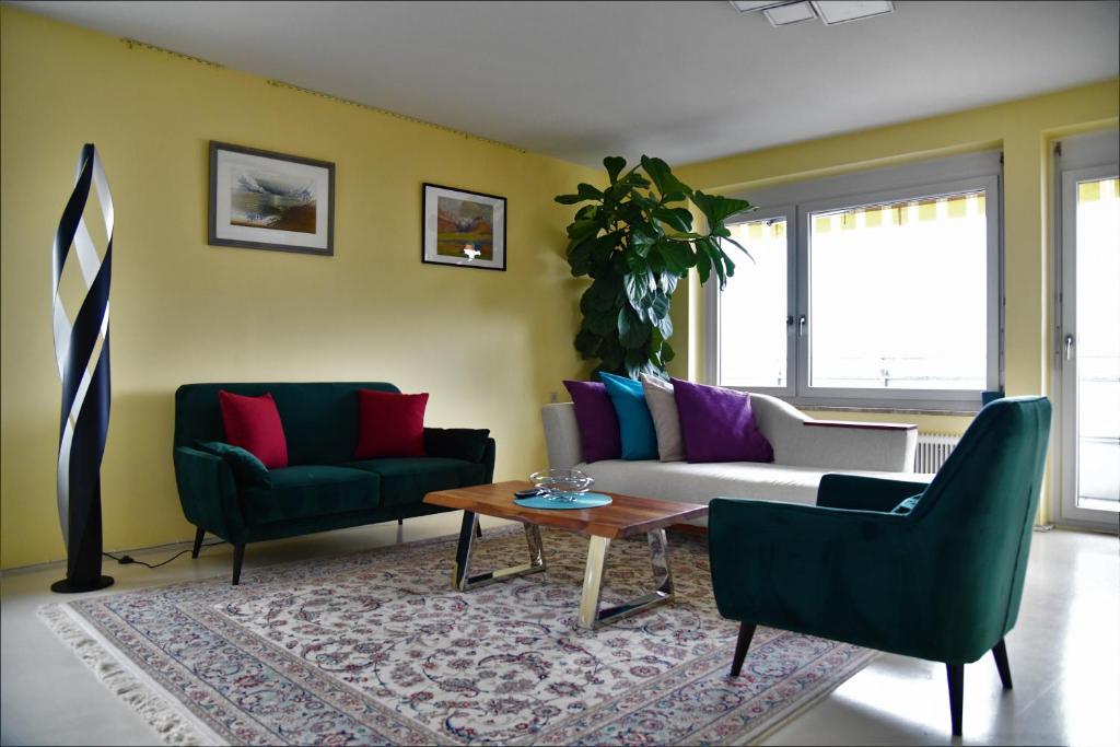 a living room with two chairs and a couch and a table at Downtown Klagenfurt Oasis in Klagenfurt
