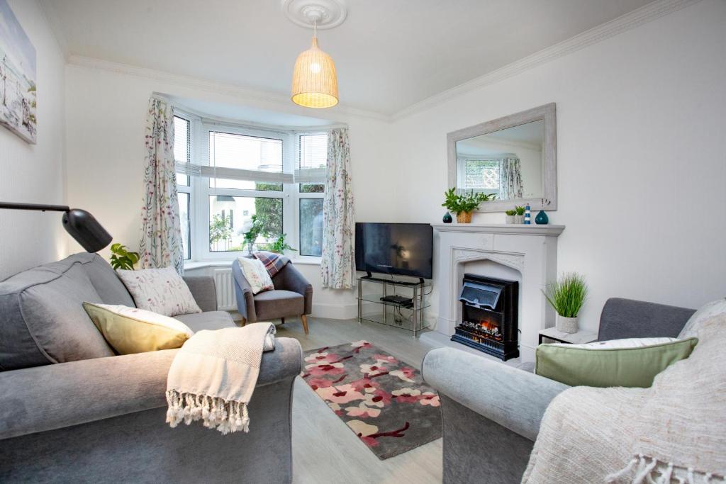 ein Wohnzimmer mit Couch und Kamin in der Unterkunft Rose Cottage in Sidmouth