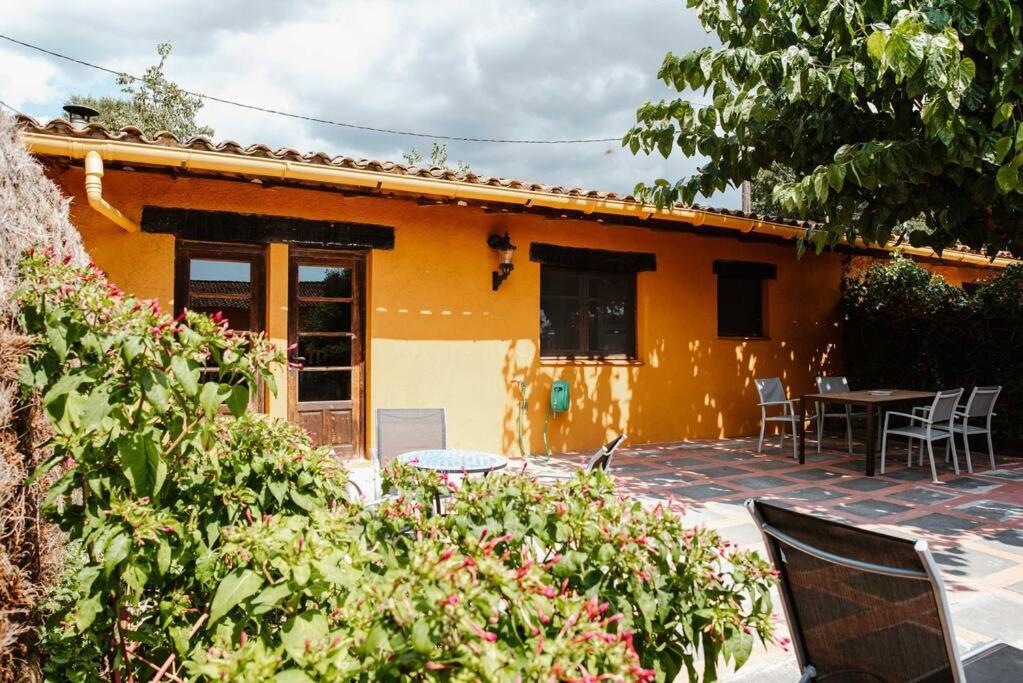 Casa de color naranja con patio, mesa y sillas en La Viña. Casa rural en el campo, en Tordera