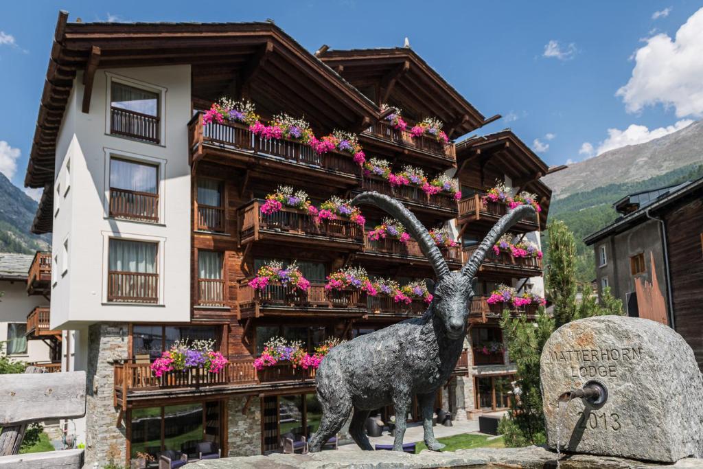 uma estátua de uma cabra em frente a um edifício em Matterhorn Lodge Boutique Hotel & Apartments em Zermatt