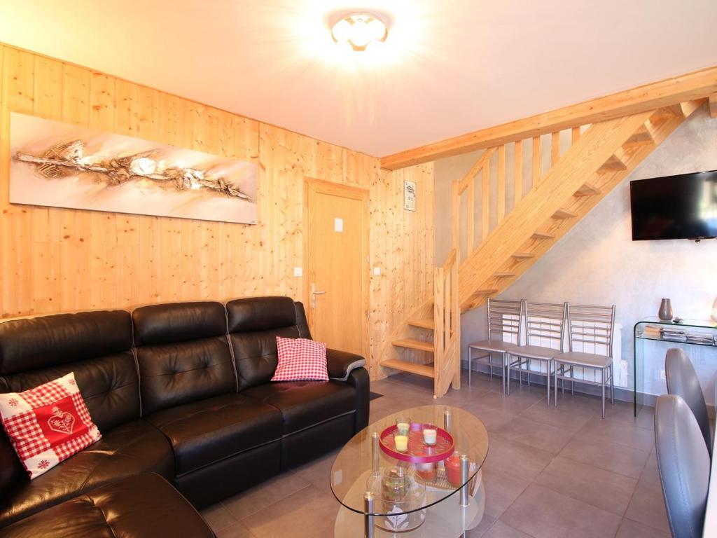 a living room with a leather couch and a table at Chalet Mont-Dore, 5 pièces, 8 personnes - FR-1-608-223 in Le Mont-Dore