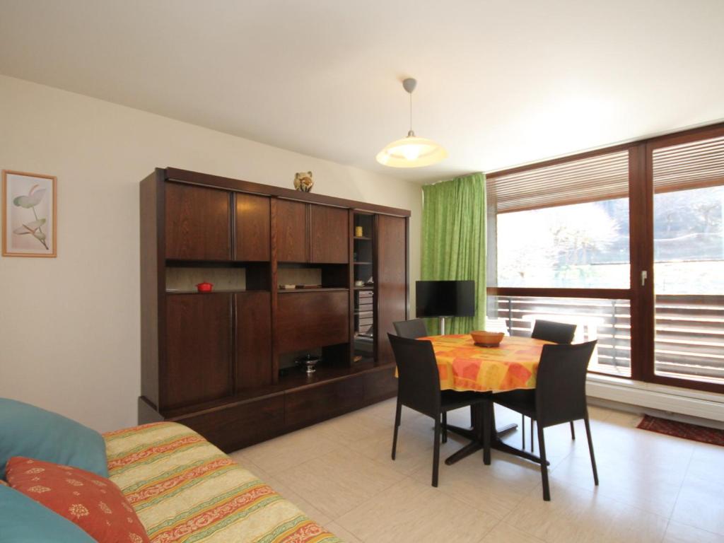 un salon avec une table, des chaises et un canapé dans l'établissement T2 avec balcon, parking privé, proche forêt, Mont-Dore - FR-1-608-212, à Le Mont-Dore