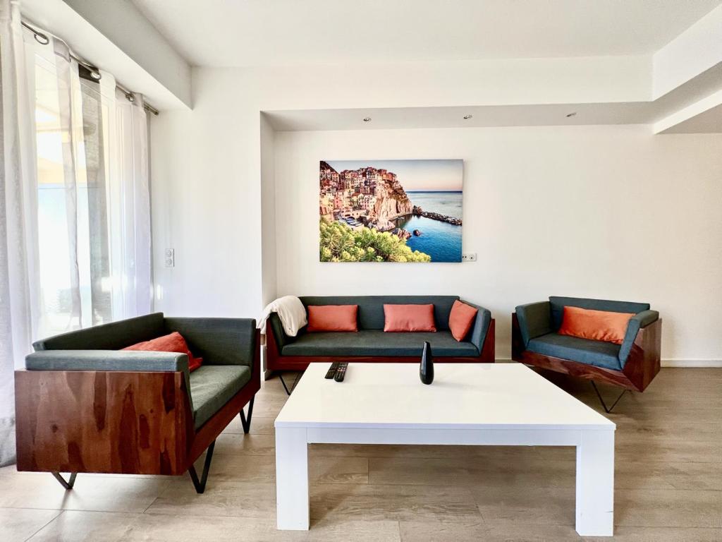 Luxurious apartment with sea view - Cannes في كان: غرفة معيشة مع كنبتين وطاولة