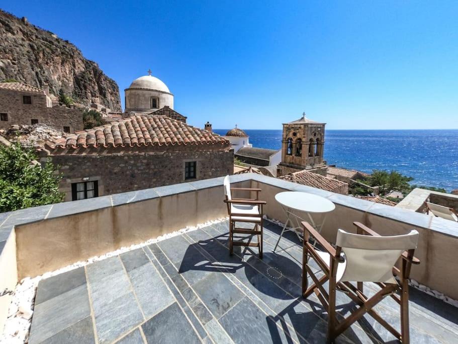 a balcony with two chairs and a view of the ocean at Κyma Mansion in Monemvasia in Monemvasia