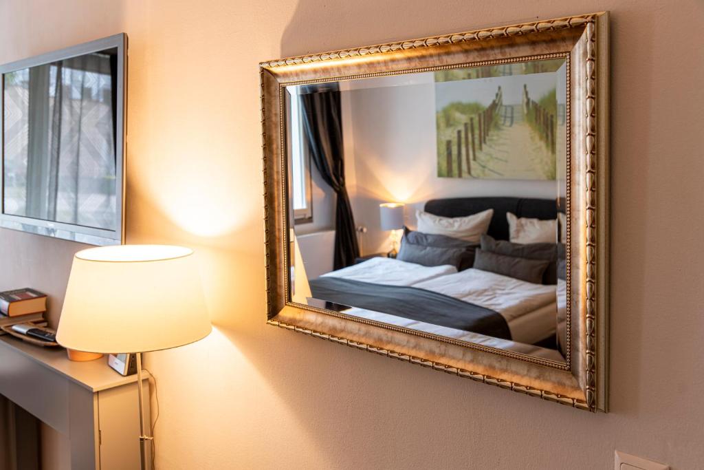 1 dormitorio con cama y espejo en la pared en Appartementhaus am Schloss, en Weimar