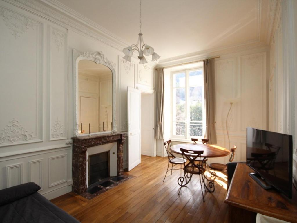 un salon avec une table et une cheminée dans l'établissement Appartement lumineux T2 avec kitchenette équipée, lave-linge et ascenseur - FR-1-608-108, à Le Mont-Dore
