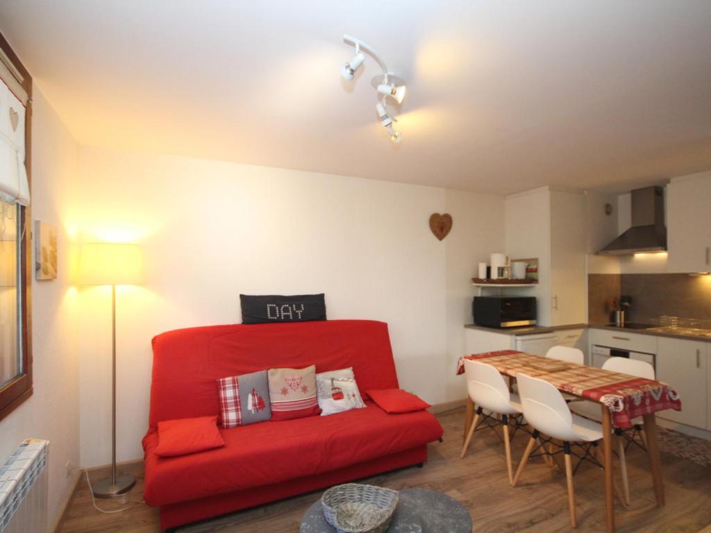 un salon avec un canapé rouge et une table dans l'établissement Charmant T2 avec Wi-Fi, garage double, proche centre Mont-Dore et thermes - FR-1-608-114, à Le Mont-Dore