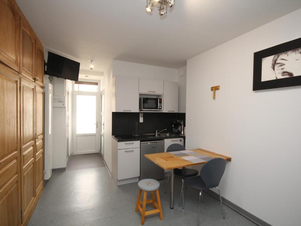 une petite cuisine avec une table en bois et une table dans l'établissement Studio Idéal au Mont-Dore: Hyper Centre, Garage Privé, Pour 3 Personnes - FR-1-608-145, à Le Mont-Dore