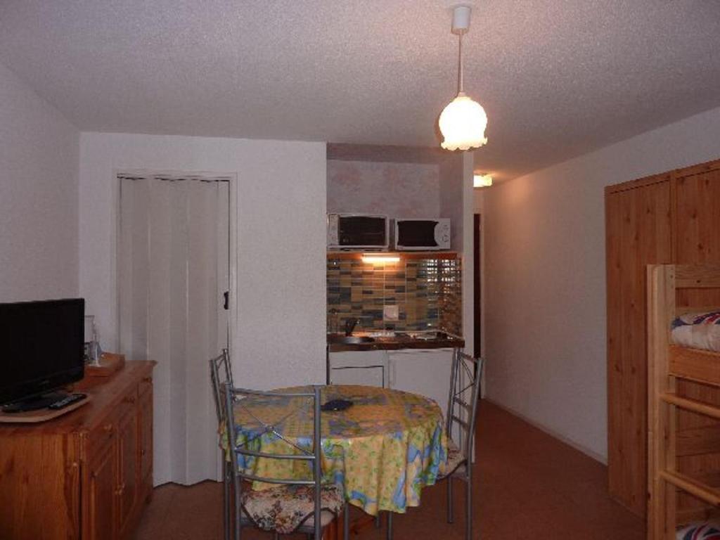 une chambre avec une table et une cuisine avec une table et des chaises dans l'établissement Studio à Mont-Dore à 200m du Centre, Parking, 4 Pers. - FR-1-608-122, à Le Mont-Dore
