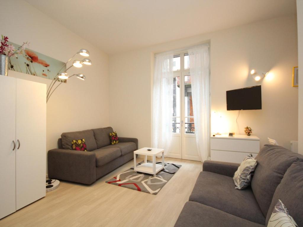un salon avec un canapé et une télévision dans l'établissement Grand Studio 27m² avec Balcon en Hyper Centre, Proche Thermes et Commodités - FR-1-608-139, à Le Mont-Dore