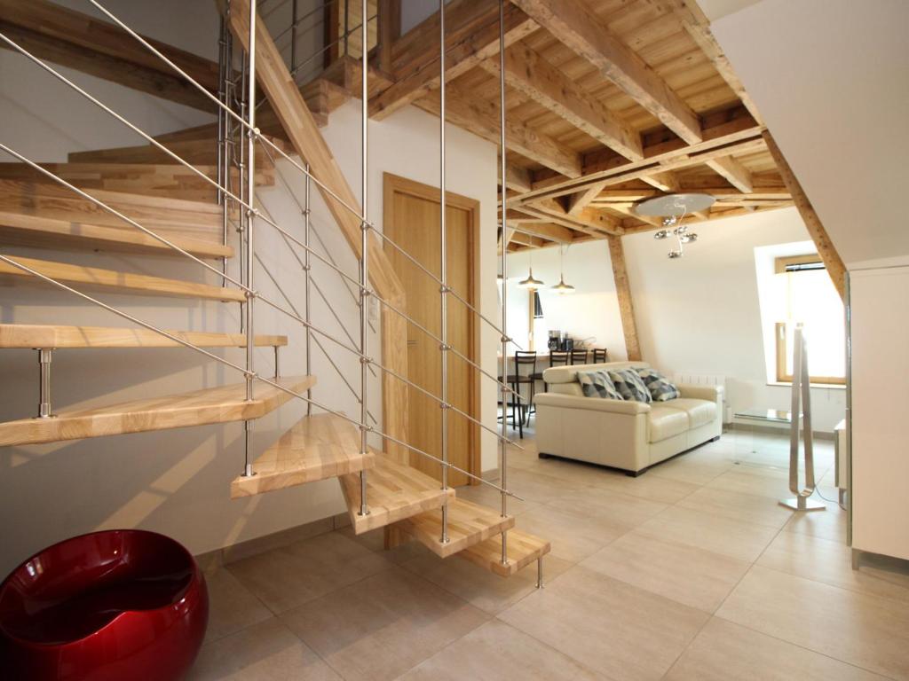 ein Wohnzimmer mit einer Wendeltreppe im Loft in der Unterkunft Charmant Duplex T3 au Mont-Dore, à 300m des Thermes, avec Parking et WiFi ! - FR-1-608-151 in Le Mont-Dore