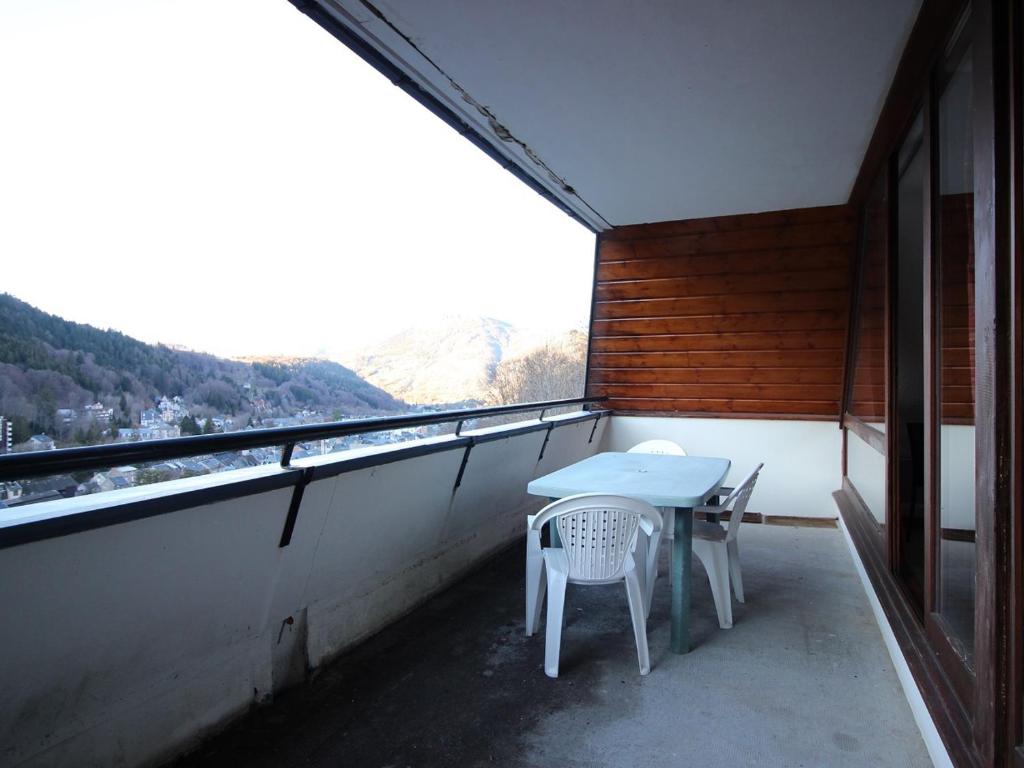 une table et des chaises sur un balcon avec vue dans l'établissement Appartement T3 avec Terrasse et Parking Privé - Mont-Dore, Proche Centre et Thermes - FR-1-608-157, à Le Mont-Dore