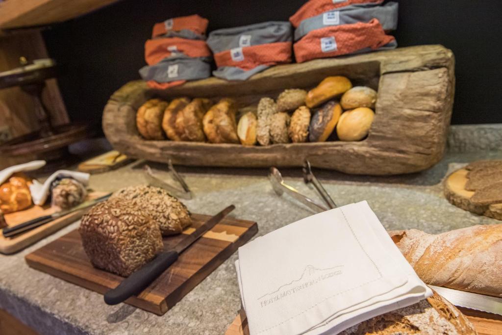 a table with bread and other baked goods on it at Matterhorn Lodge Boutique Hotel & Apartments in Zermatt