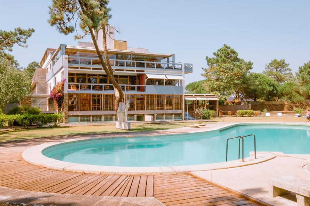 um hotel com piscina em frente a um edifício em Parque do Rio Ofir Hotel em Esposende