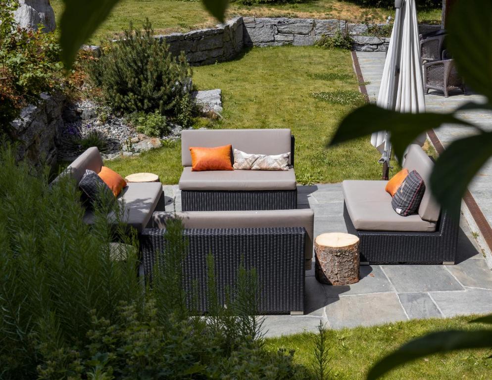 a patio with two chairs and an umbrella at Matterhorn Lodge Boutique Hotel & Apartments in Zermatt