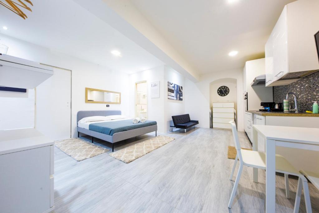 ジェノヴァにあるScirocco House by HolidayHome24のベッドとキッチン付きの広い客室です。