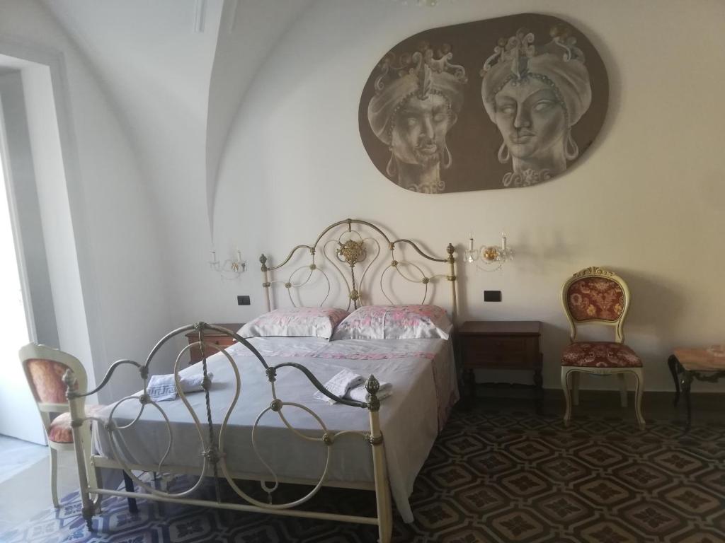 1 dormitorio con 1 cama y una foto en la pared en Terra d'Amuri Hotel, en Catania