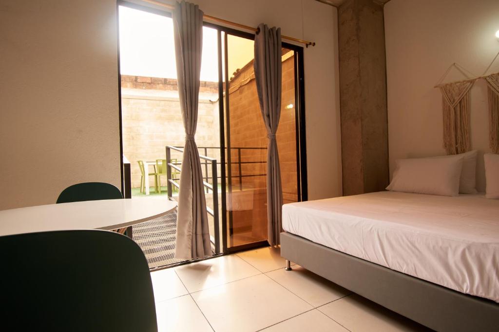 1 dormitorio con cama, mesa y balcón en MANGATA LIVING, en Medellín