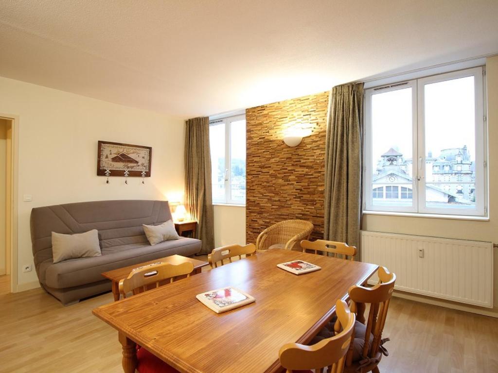 sala de estar con mesa de madera y sofá en Appartement La Bourboule, 2 pièces, 5 personnes - FR-1-608-29 en La Bourboule