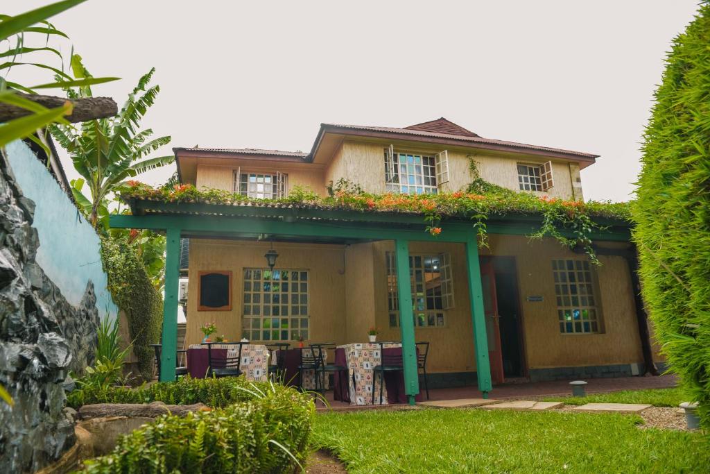 a yellow house with a green roof at Crest Safari Lodge in Arusha