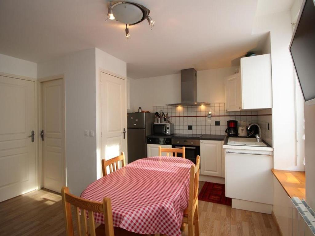 une cuisine avec une table et un chiffon de table rouge et blanc dans l'établissement T3 au Mont-Dore avec wifi, proche centre, idéal familles, 5 pers, 2 chambres - FR-1-608-35, à Le Mont-Dore