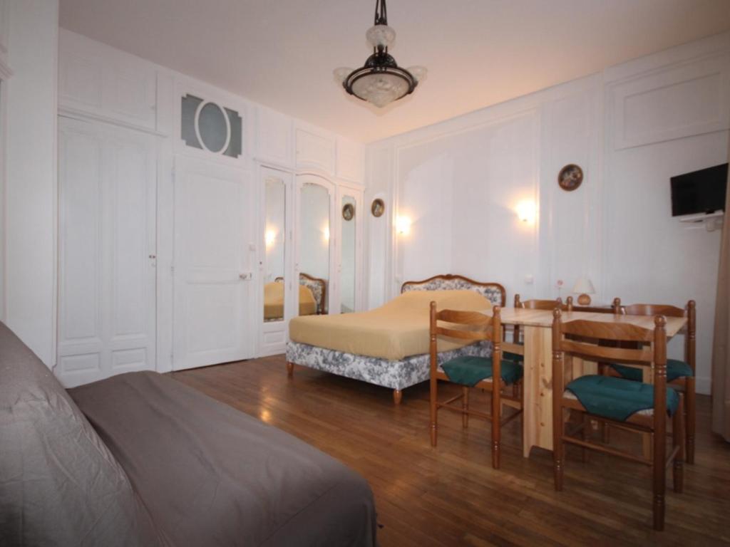 une chambre avec un lit, une table et des chaises dans l'établissement Appartement T1 avec ascenseur au centre de Mont-Dore pour 4 personnes, non accessible PMR - FR-1-608-60, à Le Mont-Dore