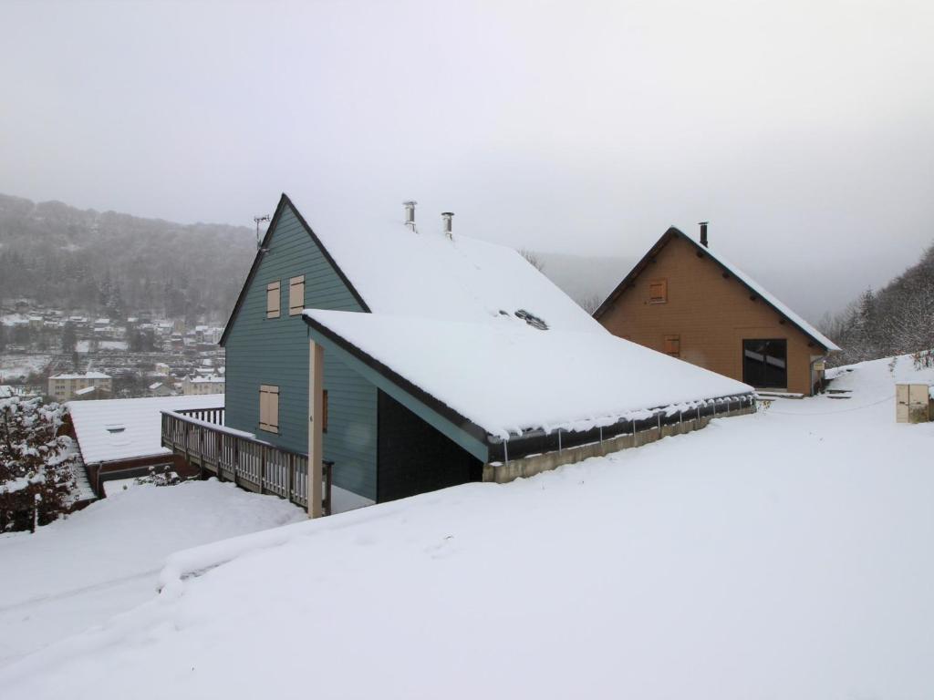 a house on top of a snow covered roof at Chalet spacieux avec terrasse et poêle à bois près du centre - FR-1-608-65 in Le Mont-Dore