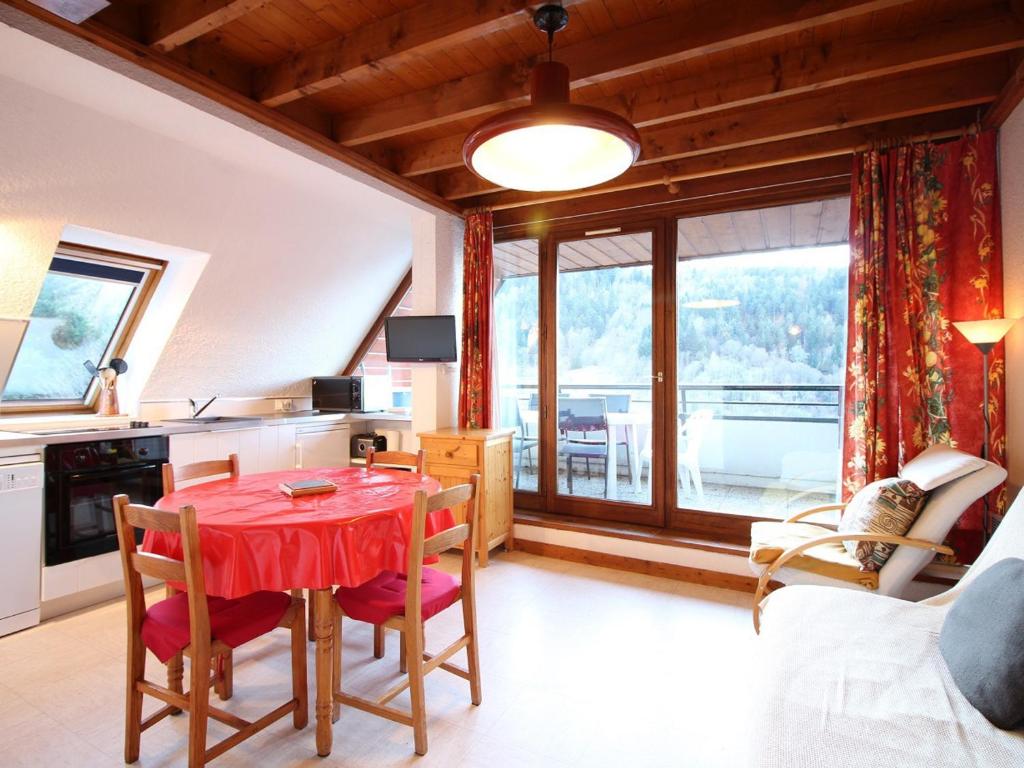 une cuisine et une salle à manger avec une table et des chaises rouges dans l'établissement Appartement Duplex T3 avec Terrasse, Parking, WiFi - FR-1-608-72, à Le Mont-Dore
