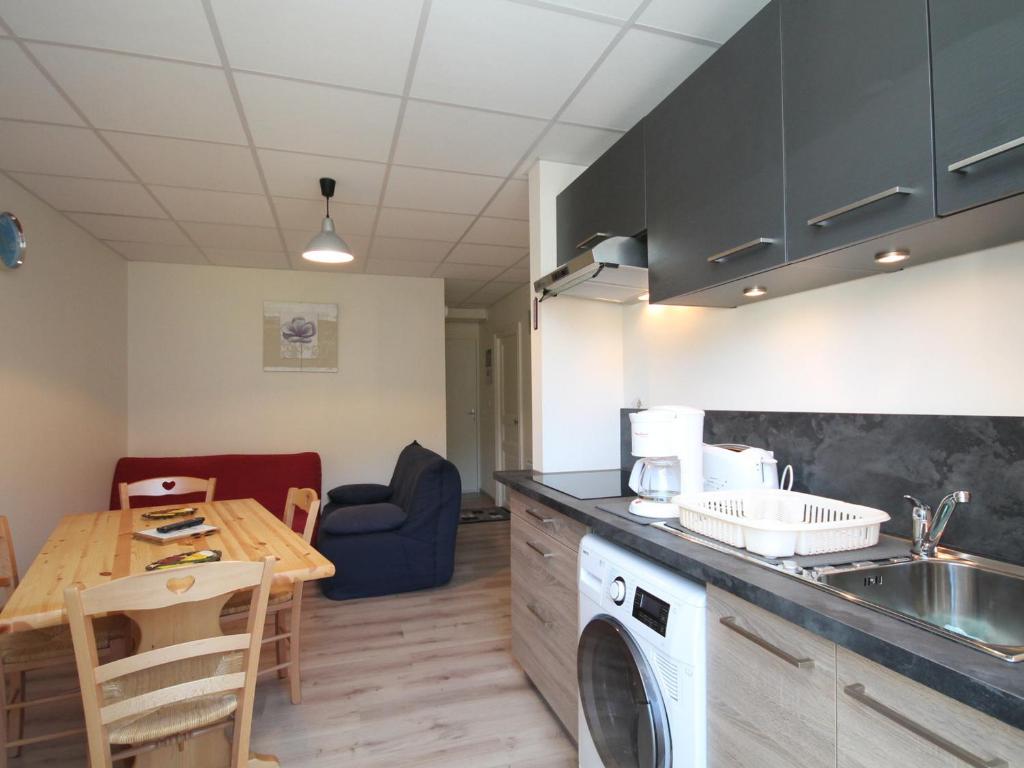 une cuisine avec une table et une machine à laver dans l'établissement Appartement T3 au Mont-Dore avec WIFI et balcon, près du centre - FR-1-608-84, à Le Mont-Dore