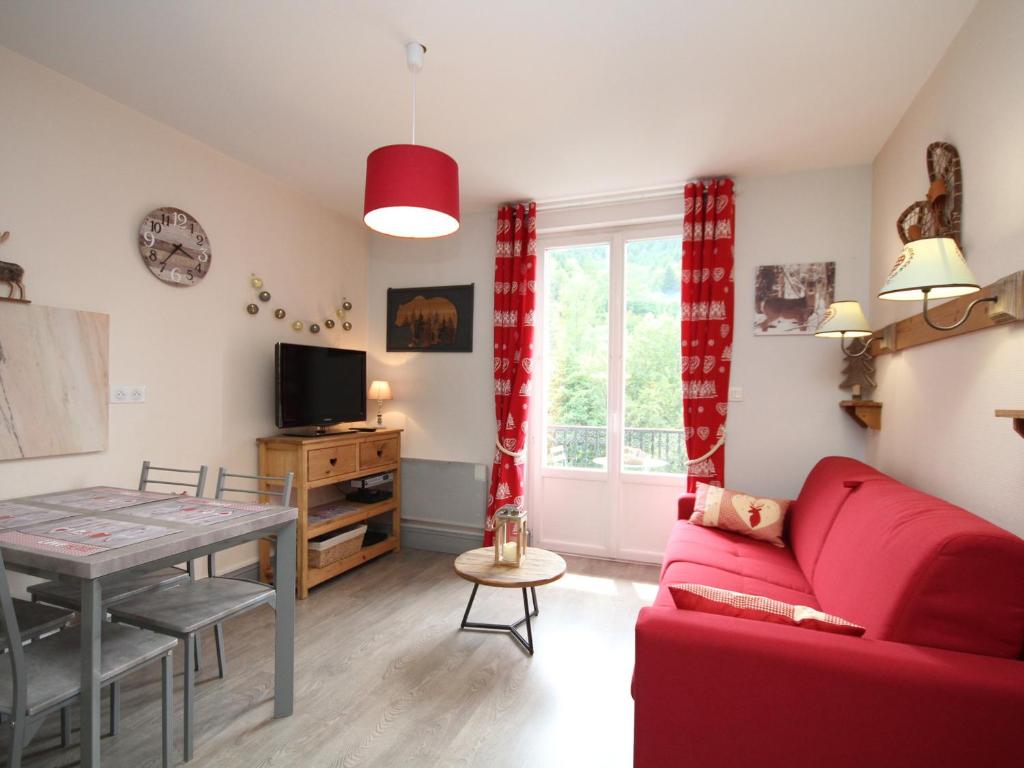 un salon avec un canapé rouge et une table dans l'établissement Charmant T2 dans hyper-centre avec wifi et balcon - Le Mont-Dore - FR-1-608-75, à Le Mont-Dore
