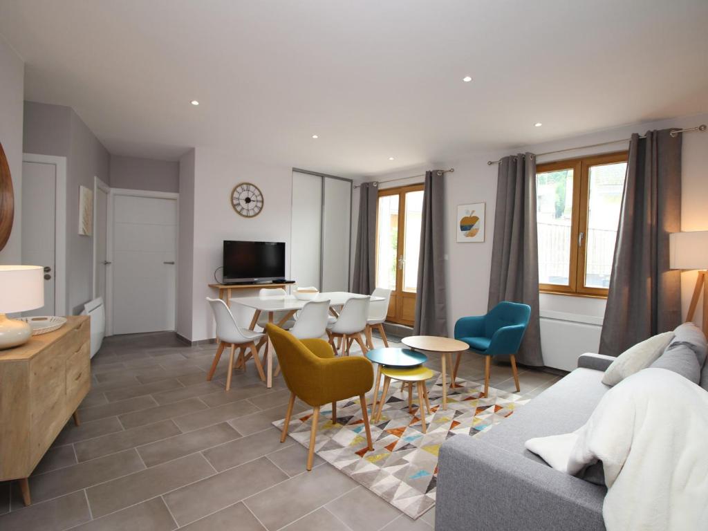 a living room with a couch and a table and chairs at Beau T3 avec terrasse, parking et wifi à 300m des Thermes du Mont-Dore - FR-1-608-79 in Le Mont-Dore