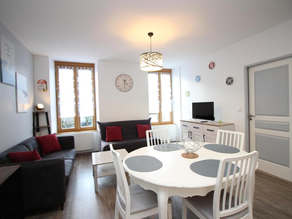 una sala de estar con una mesa y un sofá en Bel Appartement T3 avec WIFI et Parking, Résidence de Standing, 300m des Thermes au Mont-Dore - FR-1-608-87, en Le Mont-Dore