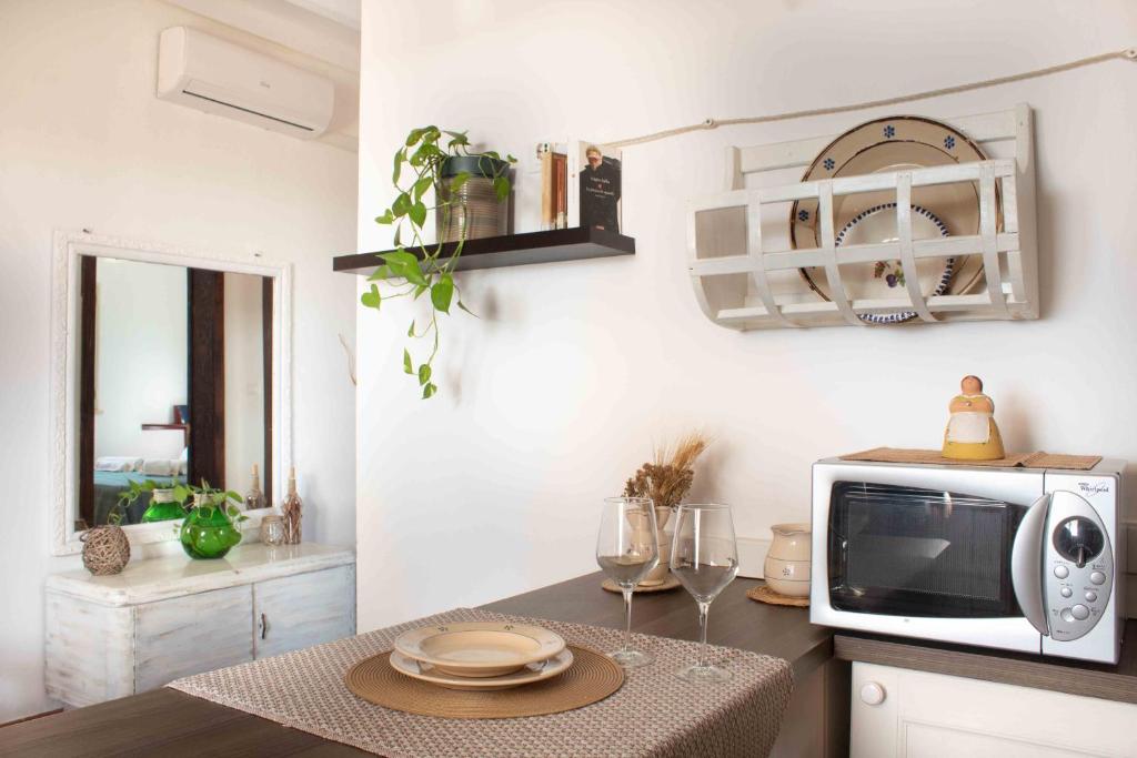 d'une cuisine équipée d'un four micro-ondes et d'une table avec des assiettes. dans l'établissement Casa Alba, à Marina di Pescoluse