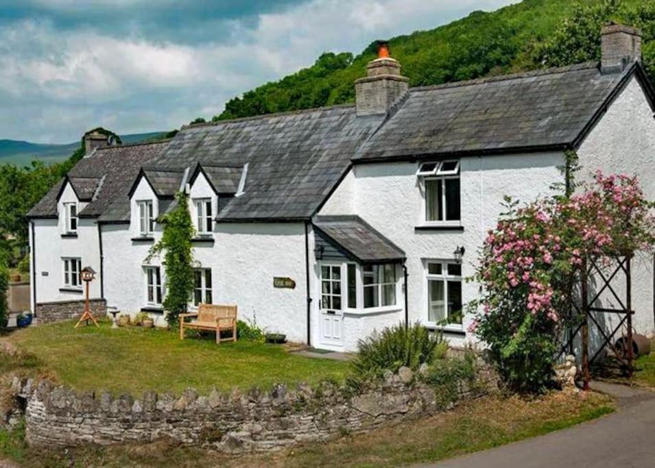 a white house with a black roof at Scenic Welsh Cottage in the Brecon Beacons in Crickhowell