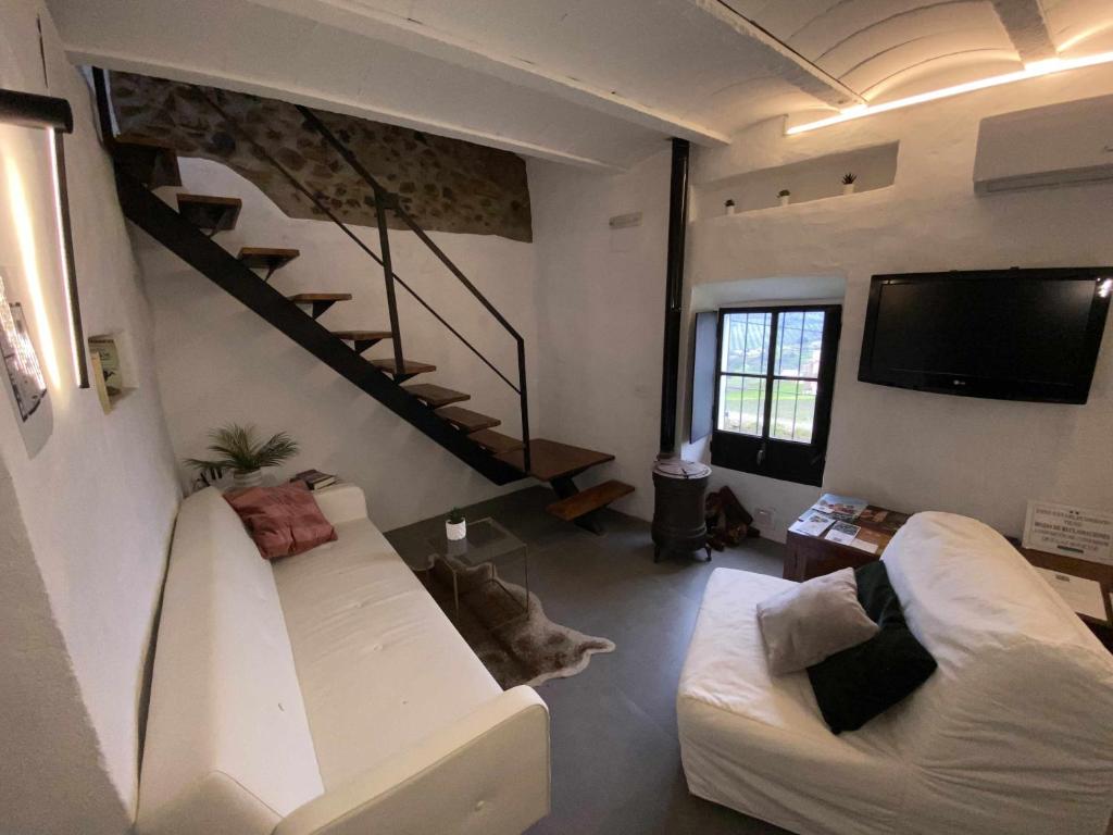ein Wohnzimmer mit 2 weißen Sofas und einem TV in der Unterkunft La Martela de Fuentes Casa de diseño rural in Fuentes de León